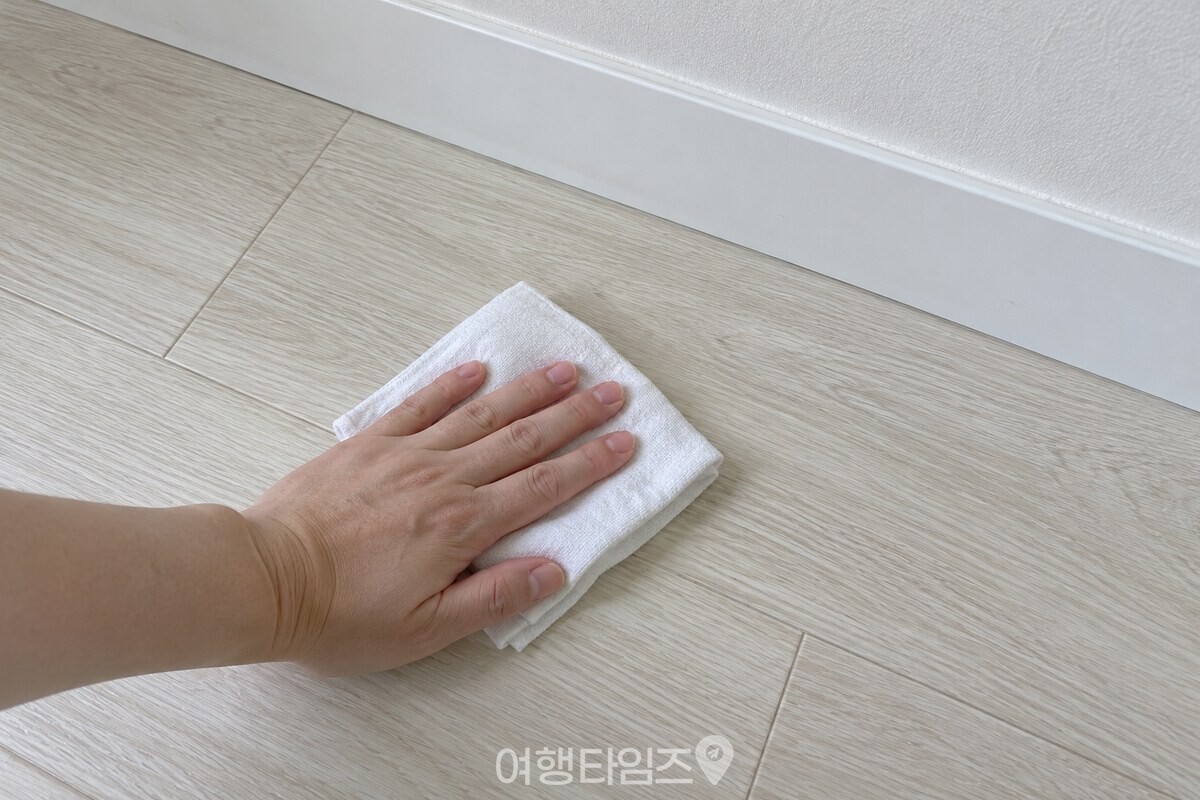 마른 흰 걸레로 장판의 한 부분을 닦는 손 / 기사 이해를 돕기 위한 생성형 이미지