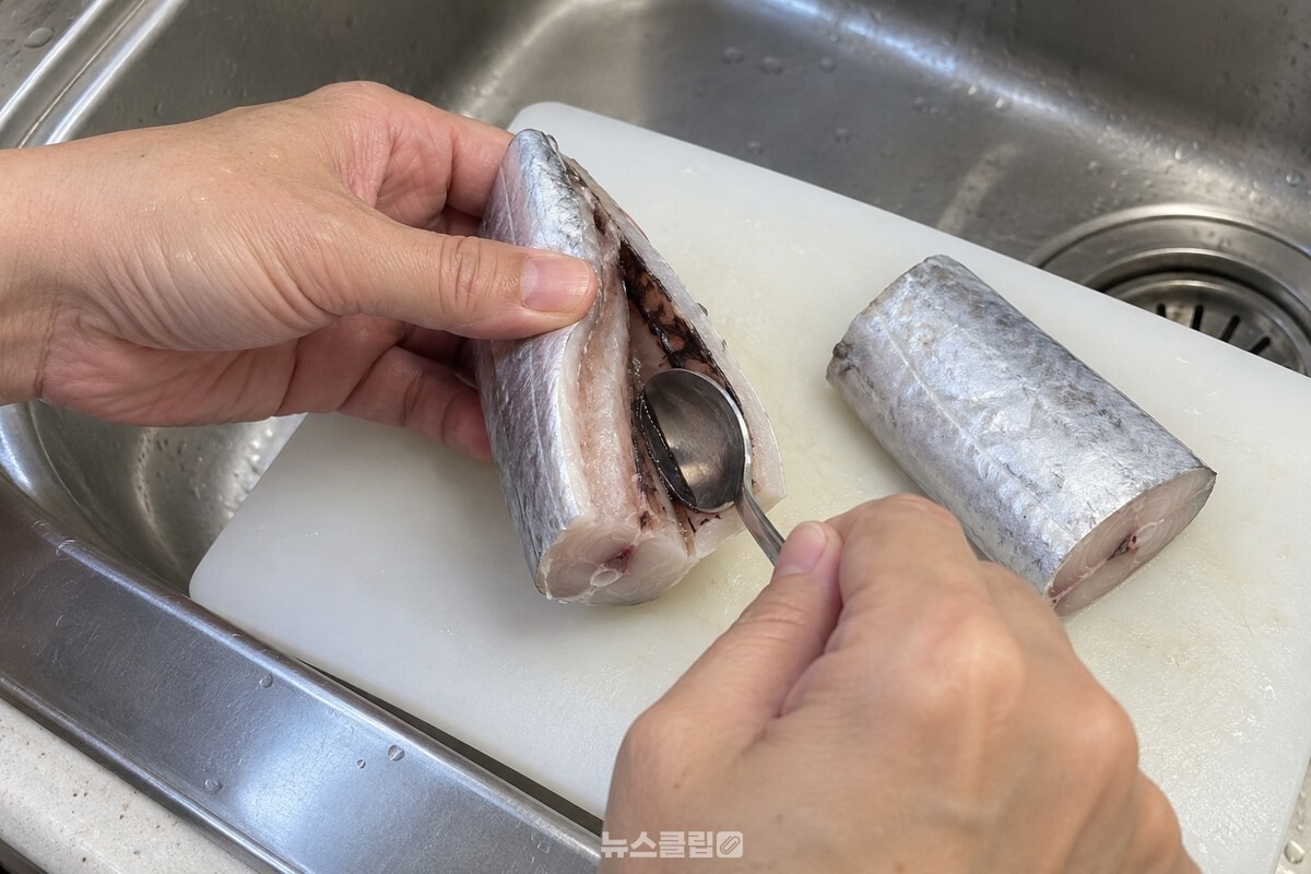 갈치 토막의 배 안쪽 검은 막을 숟가락으로 긁어 내는 손질 과정. / 기사 이해를 돕기 위한 생성형 이미지