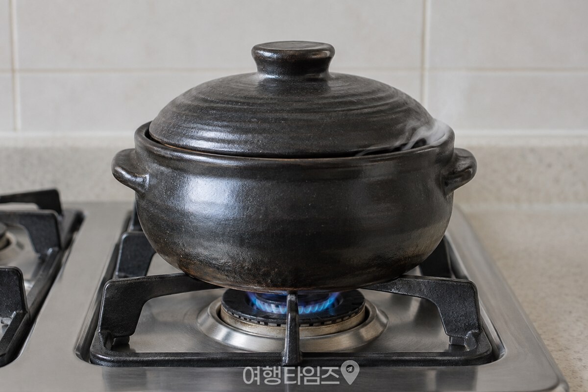 약불로 줄인 뚝배기 뚜껑 틈으로 가는 김이 나오는 모습 / 기사 이해를 돕기 위한 생성형 이미지