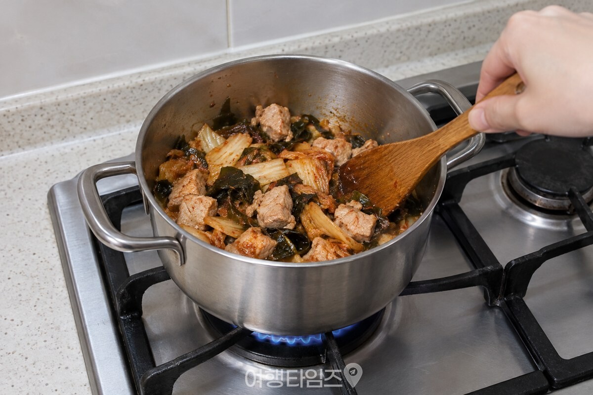 중불의 냄비에서 돼지고기와 김치, 불린 미역을 볶는 조리 단계. / 기사 이해를 돕기 위한 생성형 이미지