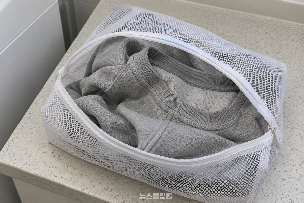 뒤집은 회색 맨투맨을 흰색 지퍼 빨래망 안에 넣어 둔 모습. / 기사 이해를 돕기 위한 생성형 이미지