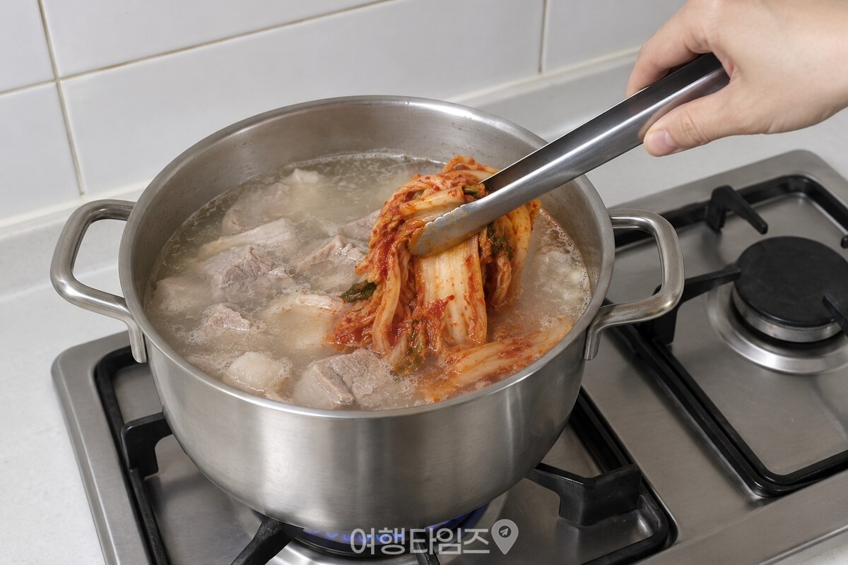 국물이 뽀얗게 끓는 냄비 가장자리로 신김치를 조금씩 넣고 있다. / 기사 이해를 돕기 위한 생성형 이미지