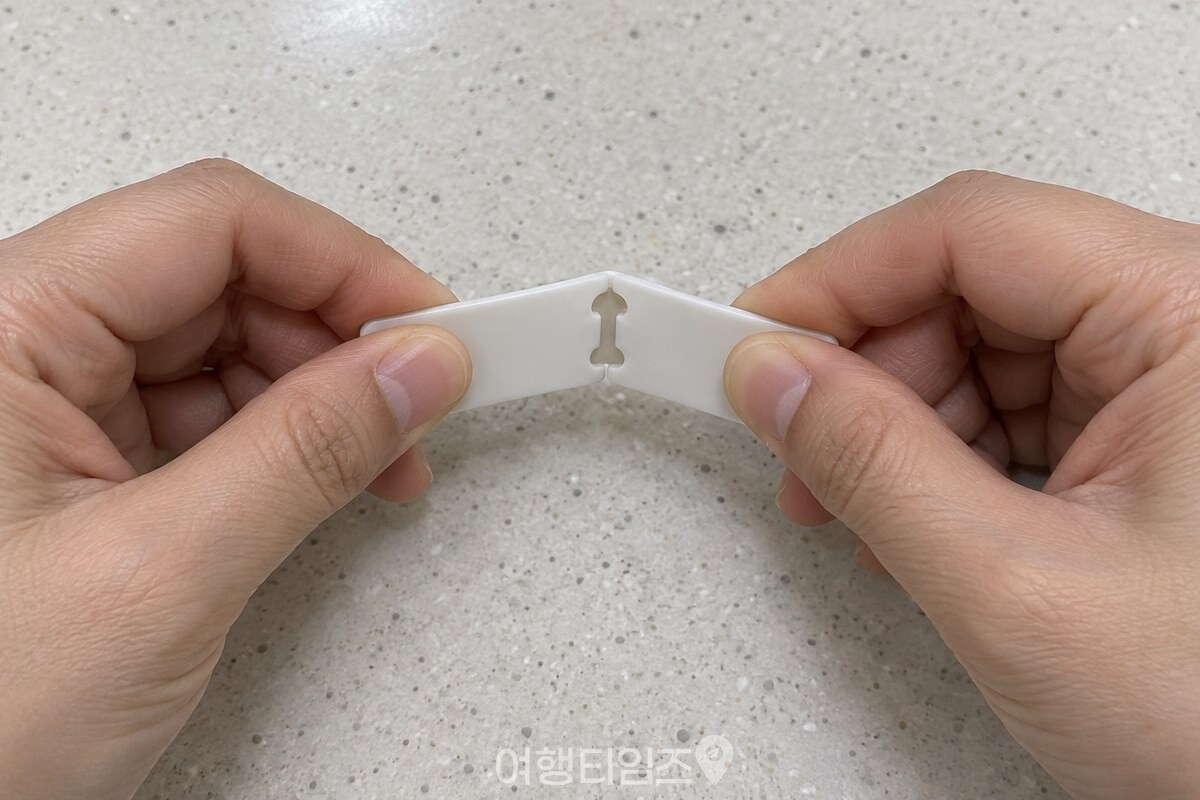 양손의 엄지와 검지로 식빵 클립 양쪽 끝을 잡고 가운데를 천천히 접는 모습. / 기사 이해를 돕기 위한 생성형 이미지