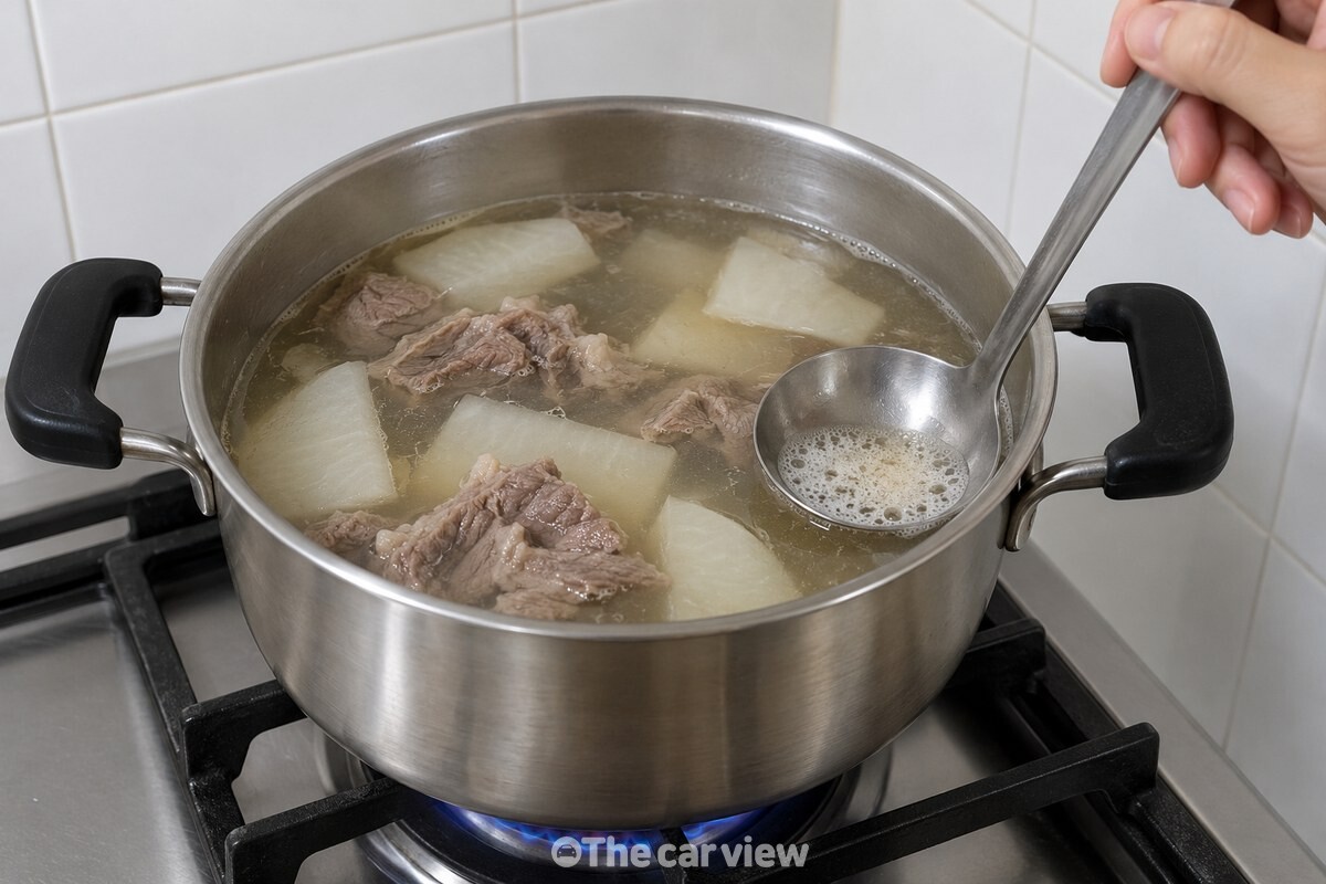 무국 표면에 올라온 작은 거품을 국자로 걷어 내는 모습. / 기사 이해를 돕기 위한 생성형 이미지