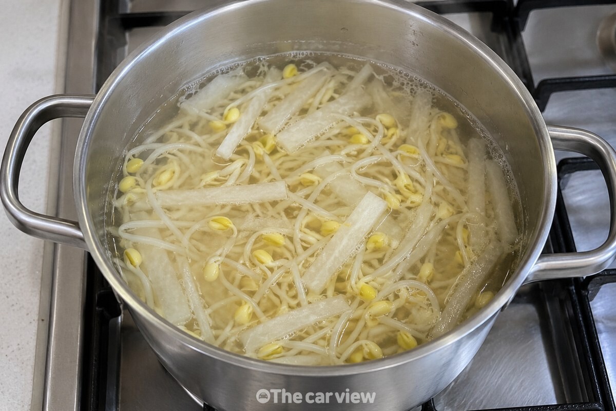 끓기 시작한 국물 속에서 무채가 투명하게 비치고 콩나물이 함께 익고 있다. / 기사 이해를 돕기 위한 생성형 이미지