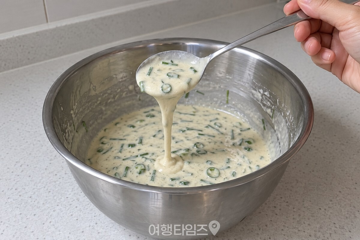부추와 청양고추가 섞인 반죽이 숟가락에서 끊기지 않고 흘러내린다. / 기사 이해를 돕기 위한 생성형 이미지