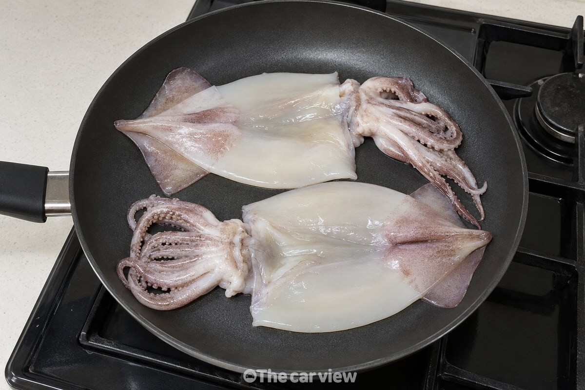 손질한 오징어 몸통과 다리를 넓은 코팅 팬에 겹치지 않게 펼쳐 놓았다. / 기사 이해를 돕기 위한 생성형 이미지