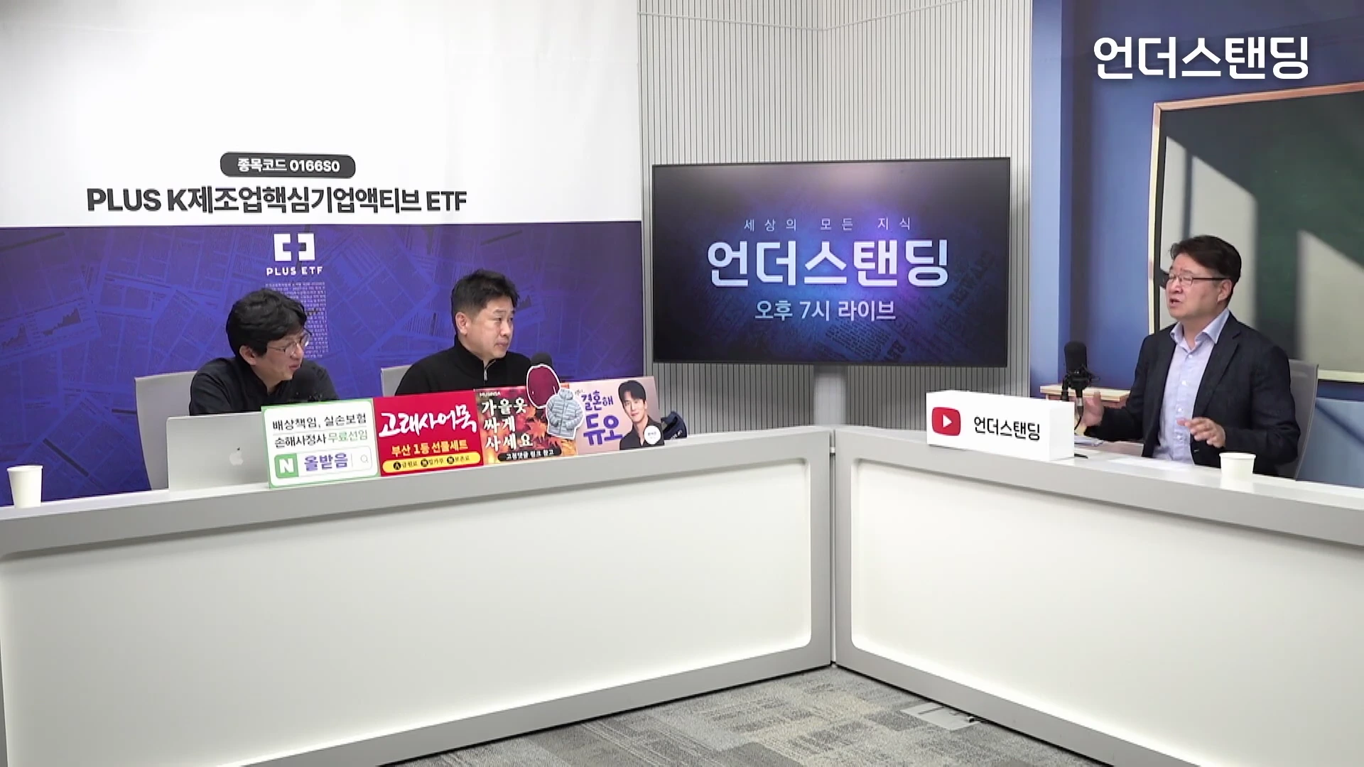 두 명의 출연자와 한 명의 진행자가 스튜디오에서 마이크를 앞에 두고 앉아 대담을 나누고 있다. 뒤편에는 큰 화면이 설치되어 있다.