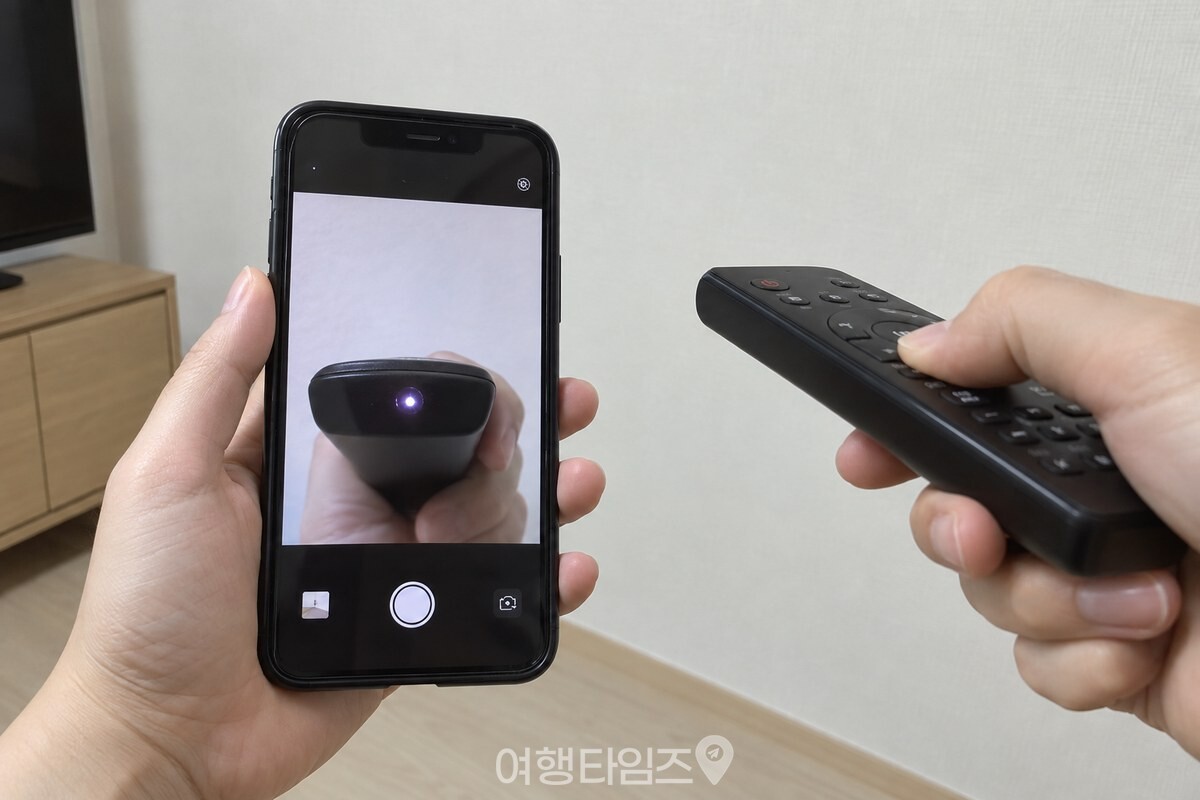휴대폰 전면 카메라 화면을 보며 리모컨 신호를 다시 확인하는 모습. / 기사 이해를 돕기 위한 생성형 이미지