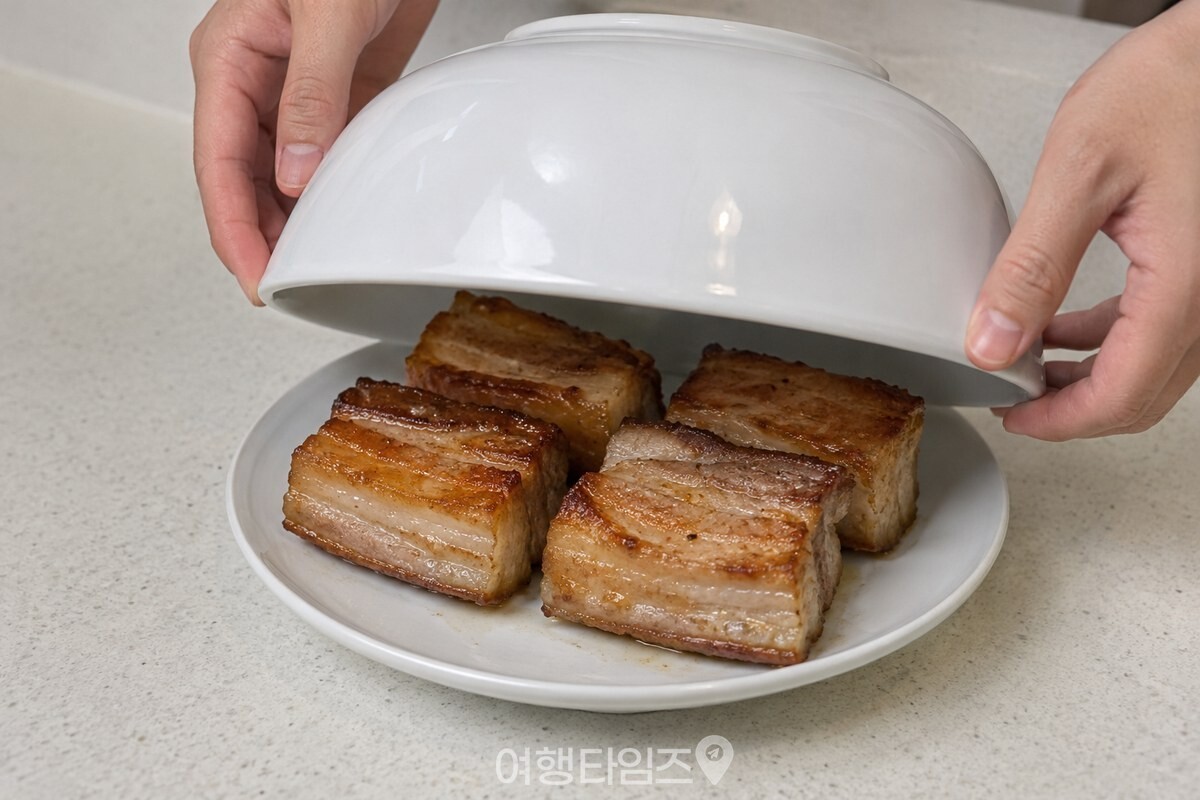 익힌 통삼겹을 접시에 담고 흰 면기로 덮어 두는 모습. / 기사 이해를 돕기 위한 생성형 이미지