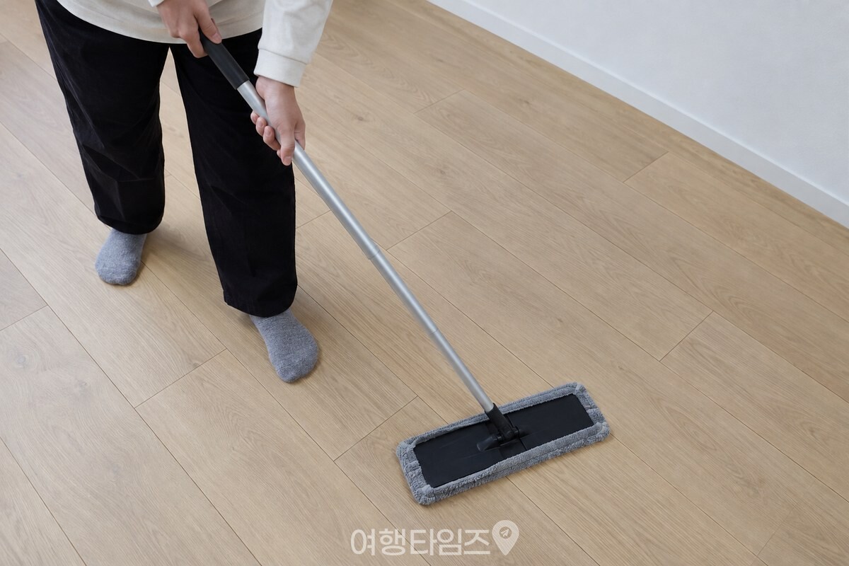 마른 극세사 걸레를 낀 밀대로 거실 강마루를 닦는 모습. / 기사 이해를 돕기 위한 생성형 이미지