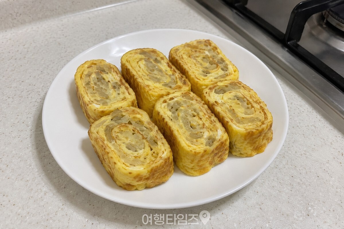 잘게 썬 당면을 넣어 두툼하게 썬 계란말이 조각이 흰 접시에 담겨 있다. / 기사 이해를 돕기 위한 생성형 이미지