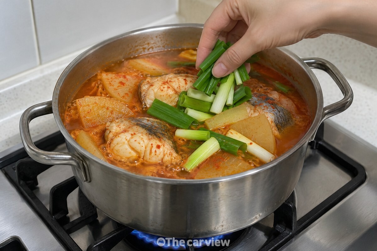 무가 반쯤 익은 국물에 동태 토막과 대파를 넣어 끓이는 모습. / 기사 이해를 돕기 위한 생성형 이미지