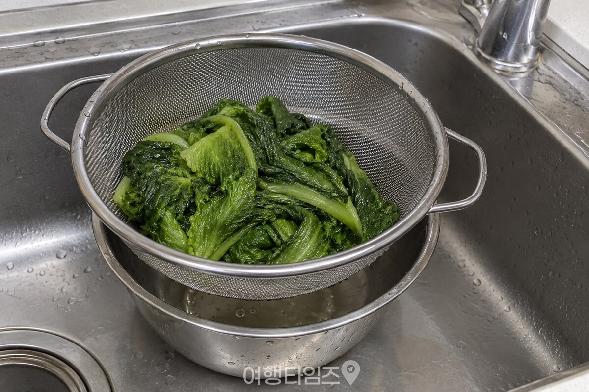 체에 밭친 데친 상추의 잎 사이에서 물기가 빠지는 모습. / 기사 이해를 돕기 위한 생성형 이미지