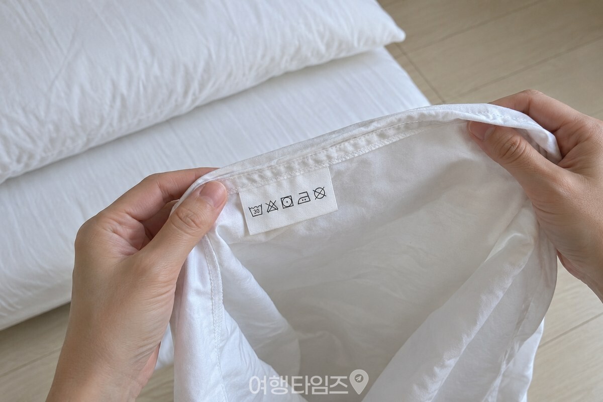 베개커버 안쪽의 세탁 표시를 가까이에서 확인하는 모습. / 기사 이해를 돕기 위한 생성형 이미지