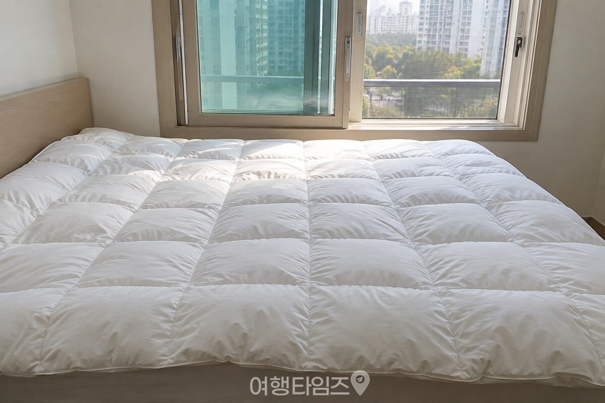 창문을 연 방의 침대 위에 털이불을 끝까지 펼쳐 공기를 들이고 있다. / 기사 이해를 돕기 위한 생성형 이미지