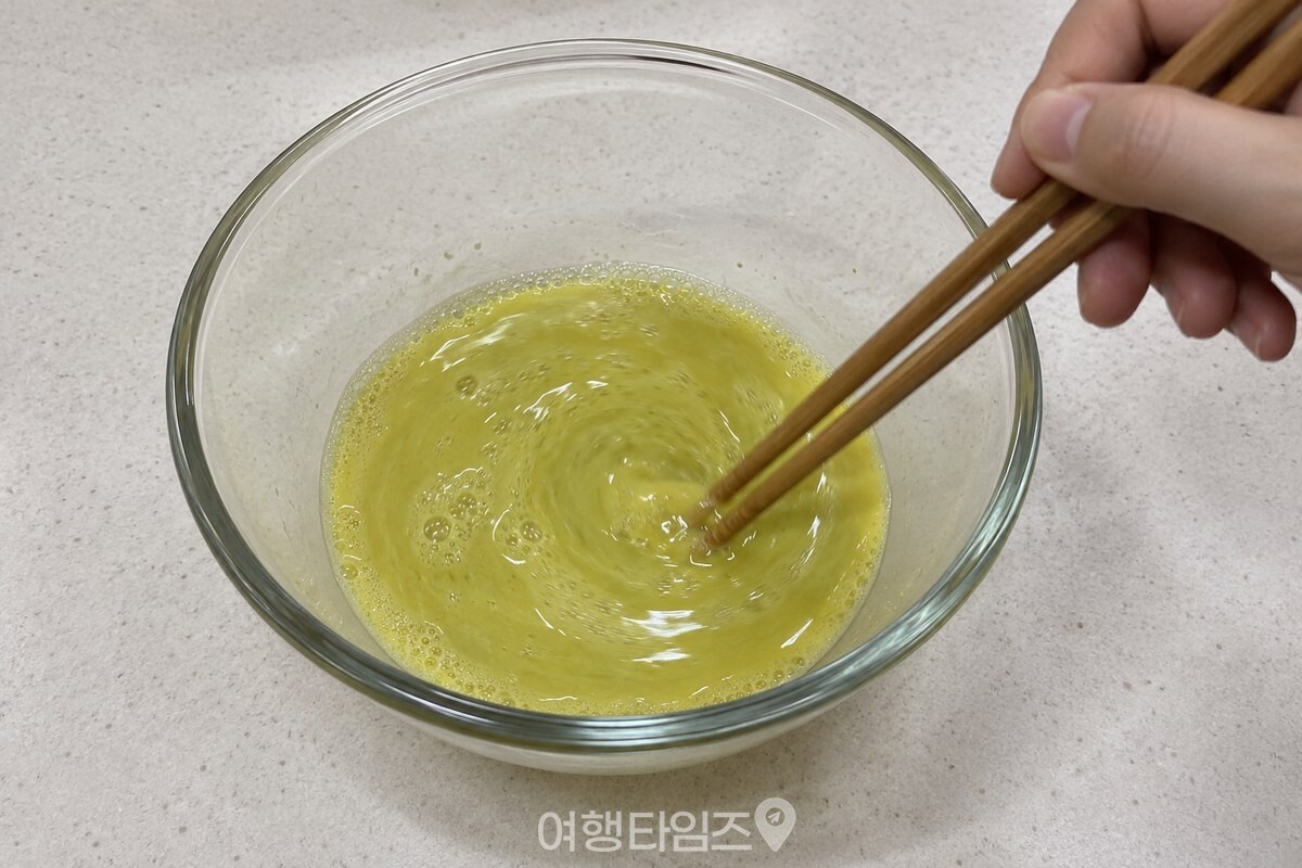 연한 연둣빛 달걀물을 젓가락으로 고르게 섞는 모습. / 기사 이해를 돕기 위한 생성형 이미지