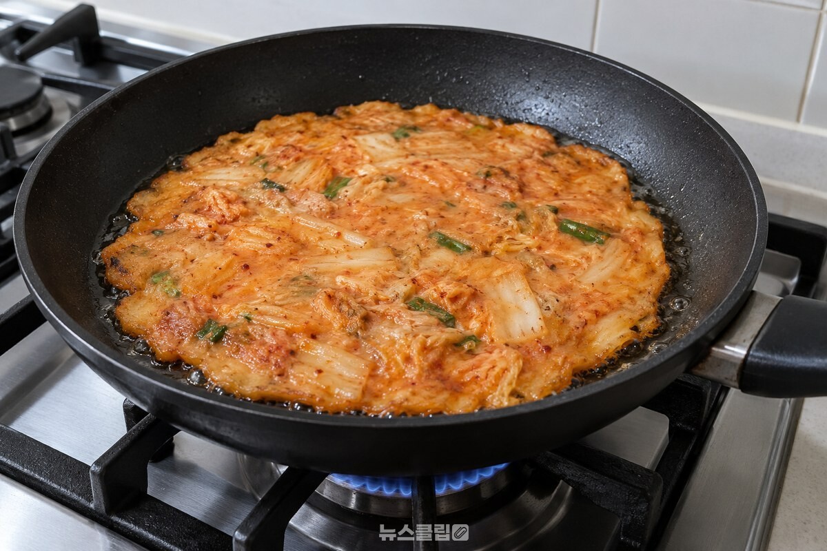 얇게 부친 김치전의 가장자리와 가운데가 팬 위에서 함께 보인다. / 기사 이해를 돕기 위한 생성형 이미지