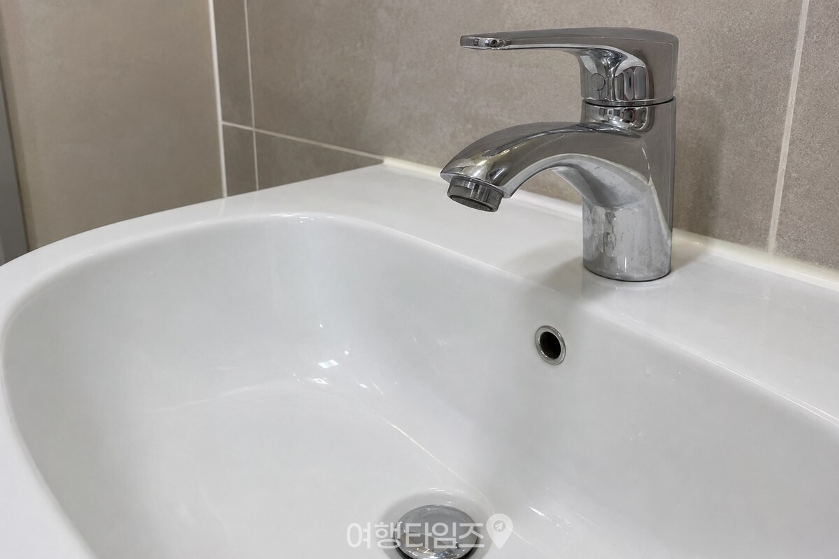 세면대 수전의 물 나오는 꼭지와 손잡이 표면을 가까이에서 본 모습 / 기사 이해를 돕기 위한 생성형 이미지