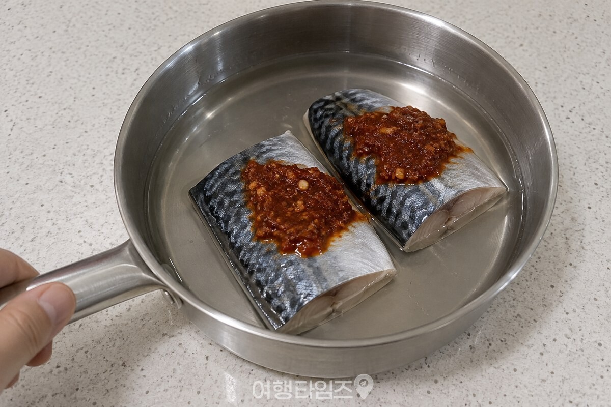 양념을 얹은 고등어가 물에 살짝 잠기도록 냄비에 담긴 조리 전 모습. / 기사 이해를 돕기 위한 생성형 이미지