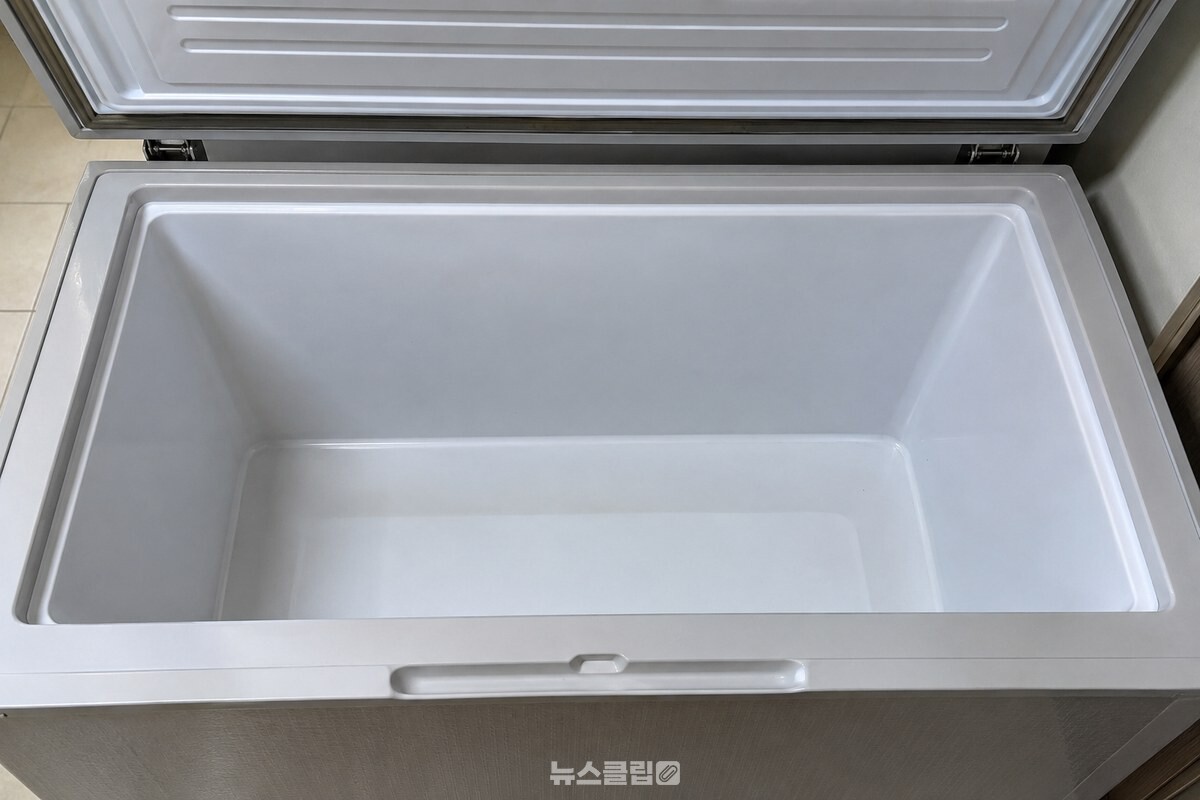 뚜껑을 연 김치냉장고 칸 안쪽 벽과 정리된 김치통 자리. / 기사 이해를 돕기 위한 생성형 이미지