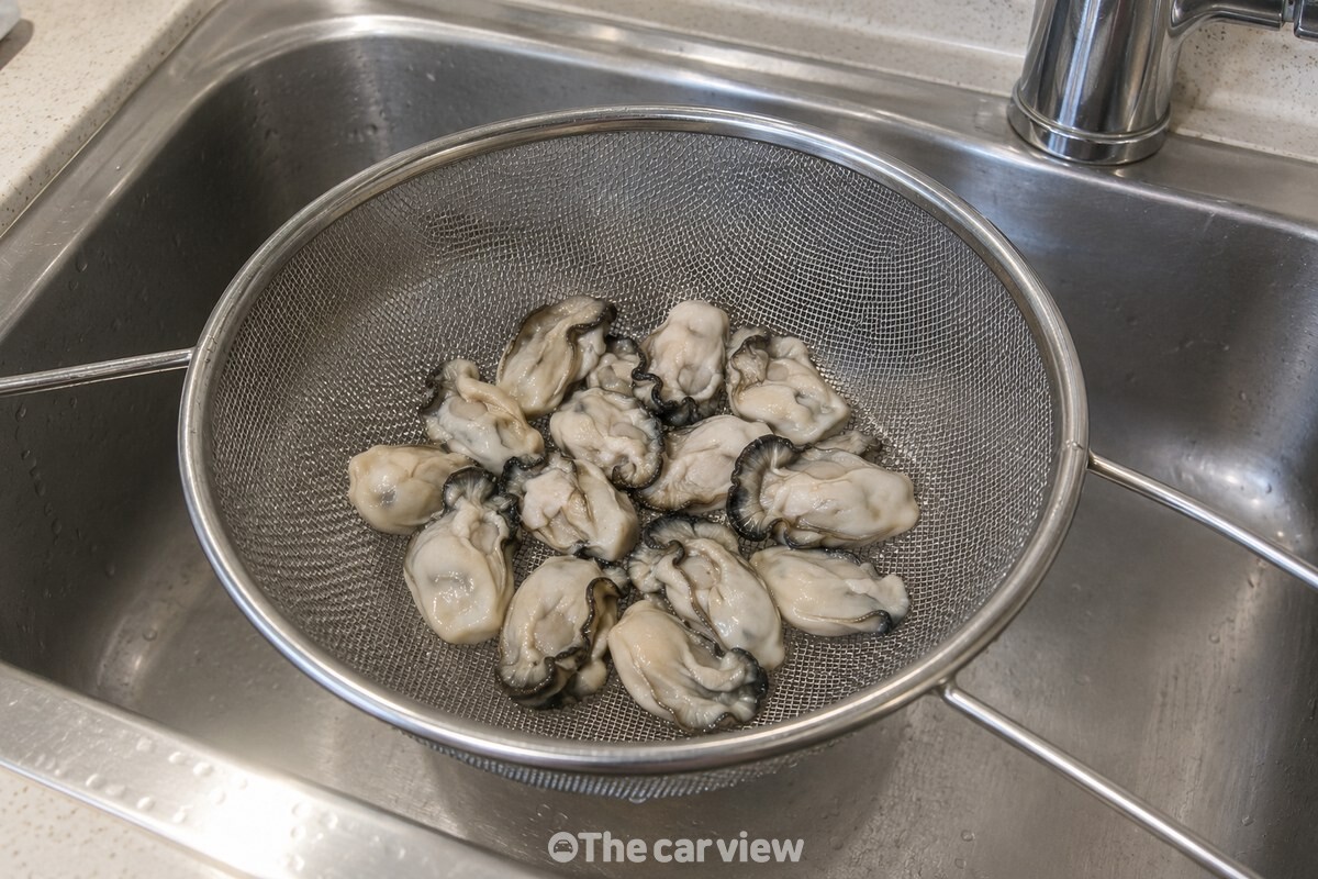 살짝 데친 굴을 체에 펼쳐 두어 물기를 빼고 있다. / 기사 이해를 돕기 위한 생성형 이미지