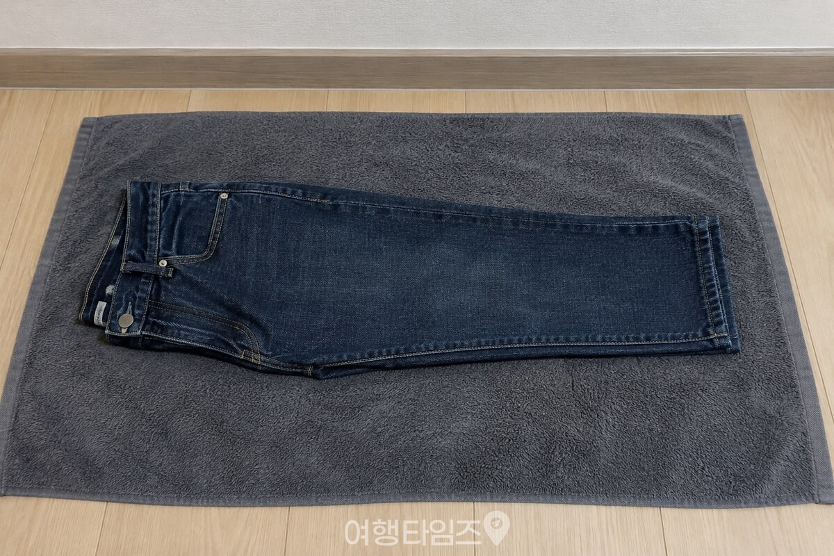 펼친 마른 목욕 수건 위에 청바지를 겹치지 않게 반으로 접어 올린 모습이다. / 기사 이해를 돕기 위한 생성형 이미지