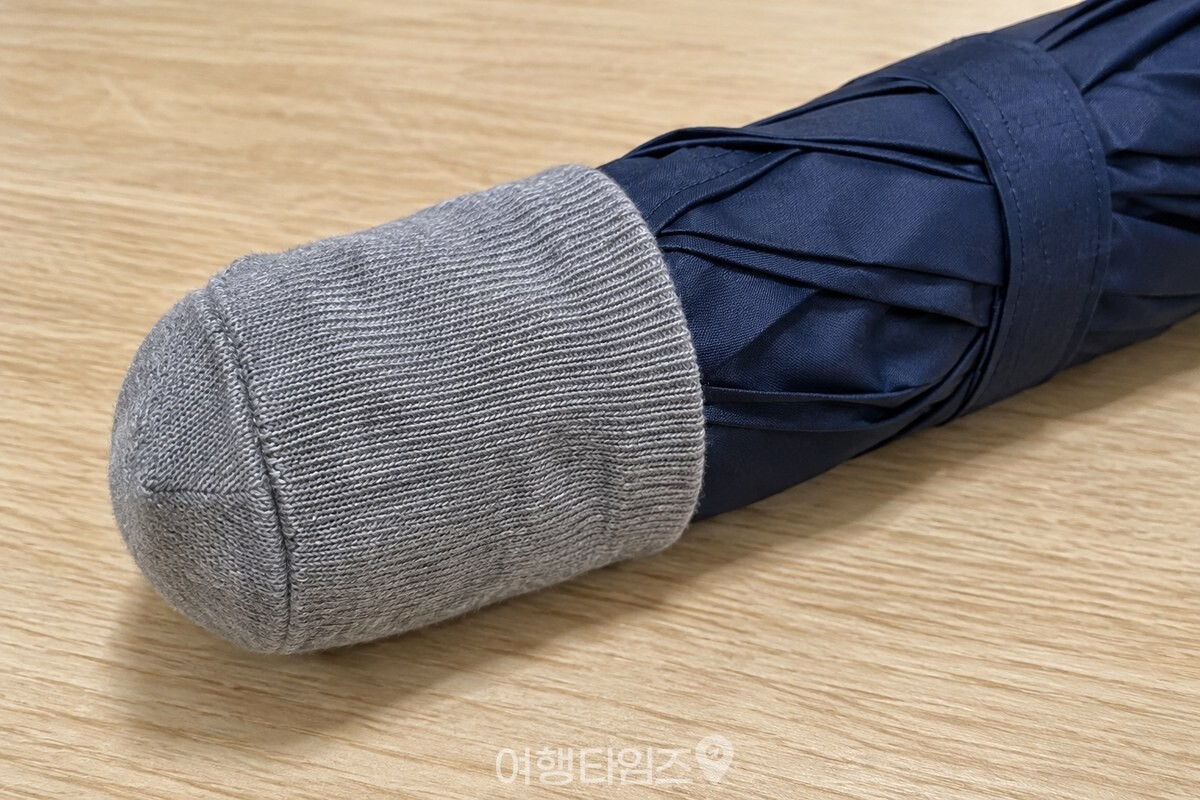 접어 묶은 우산의 끝을 막아 주는 양말 발끝 부분이 가까이 보인다. / 기사 이해를 돕기 위한 생성형 이미지