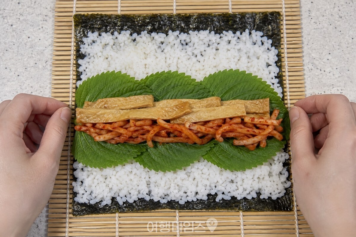 밥 위에 깻잎을 겹쳐 깔고 무말랭이무침과 어묵을 올린 김밥 속. / 기사 이해를 돕기 위한 생성형 이미지