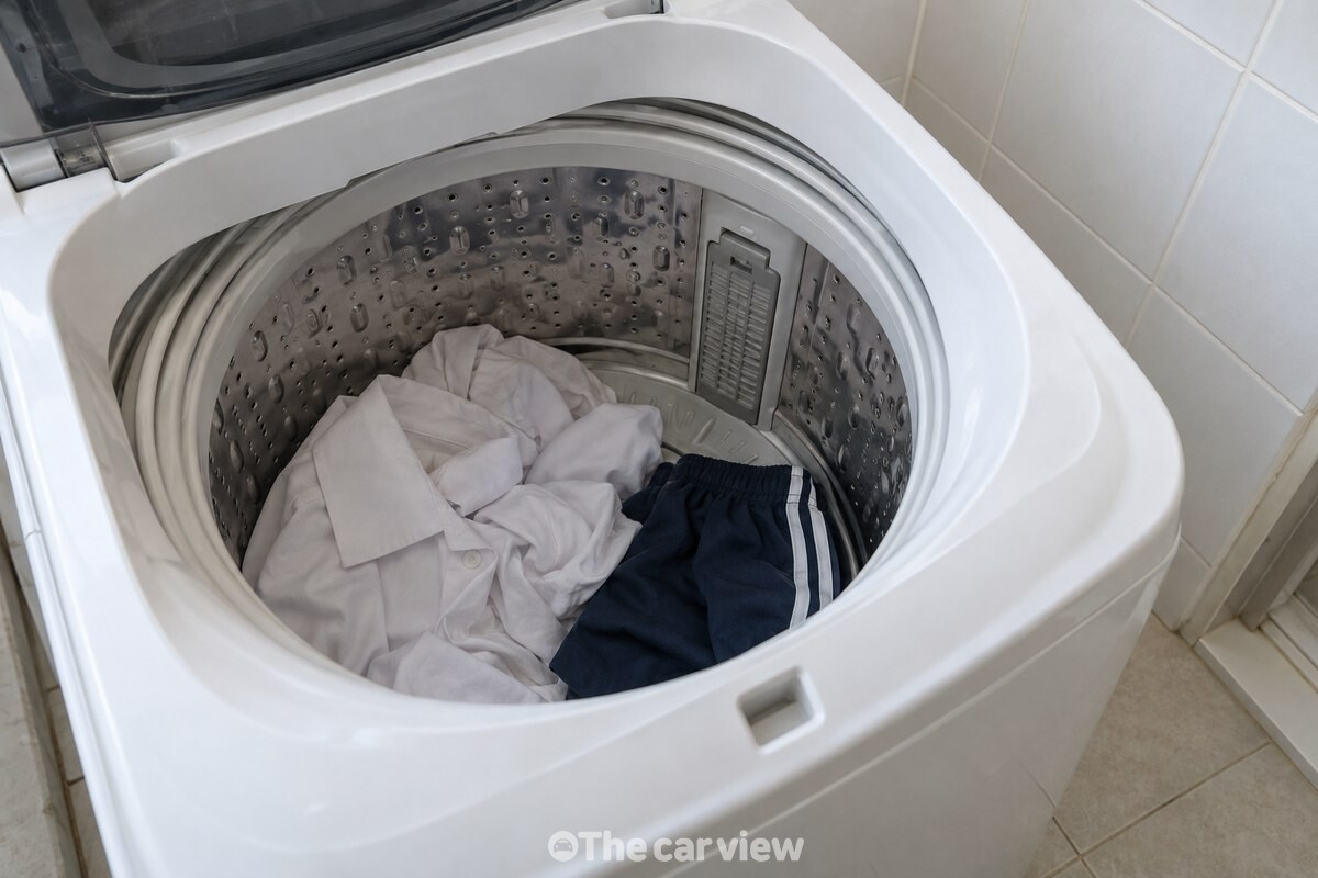 통돌이 세탁기 안쪽의 필터와 빨랫감을 함께 확인하는 장면. / 기사 이해를 돕기 위한 생성형 이미지