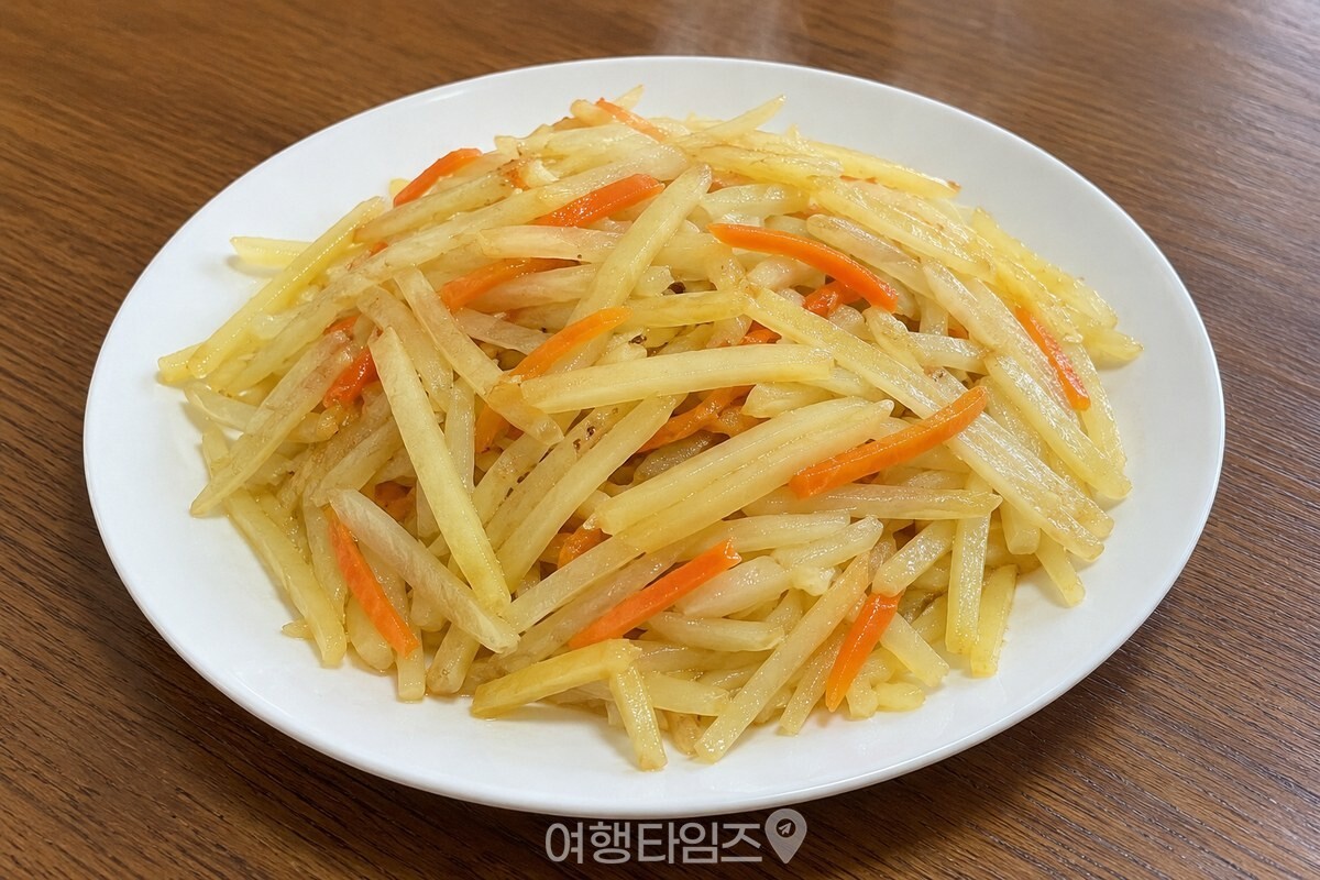 접시에 담긴 감자채볶음에 길쭉한 감자채와 당근채가 고르게 보인다. / 기사 이해를 돕기 위한 생성형 이미지