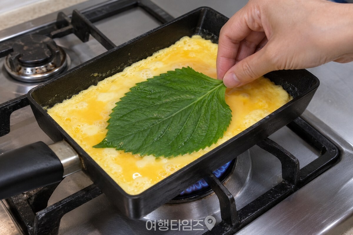 팬 가장자리는 익고 가운데는 촉촉한 달걀물 위에 깻잎을 올릴 때의 모습이다. / 기사 이해를 돕기 위한 생성형 이미지