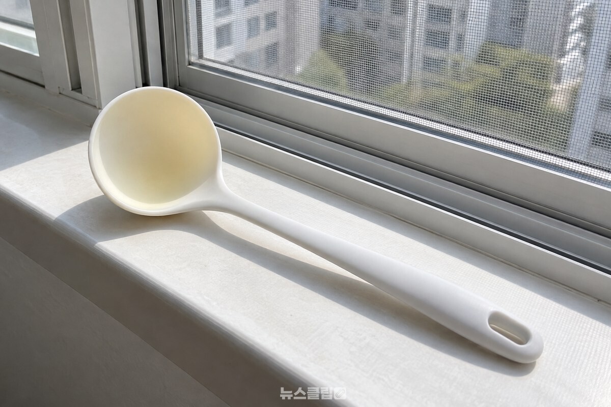볕이 드는 베란다 창가에 노란 기운이 옅어진 실리콘 국자를 안쪽이 보이게 놓아 둔 모습. / 기사 이해를 돕기 위한 생성형 이미지