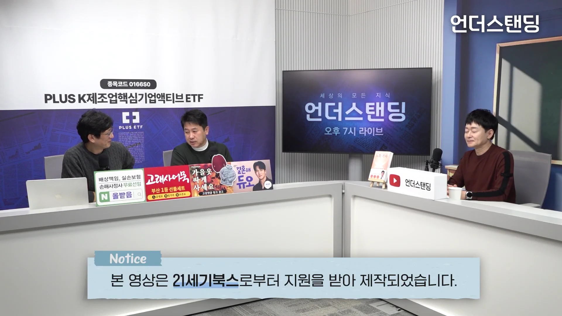 스튜디오에 세 명의 남성이 흰색 테이블을 사이에 두고 앉아 대화를 나누고 있는 모습으로, 배경에는 대형 모니터와 로고가 보이며 하단에는 지원 문구가 적힌 박스가 떠 있습니다.