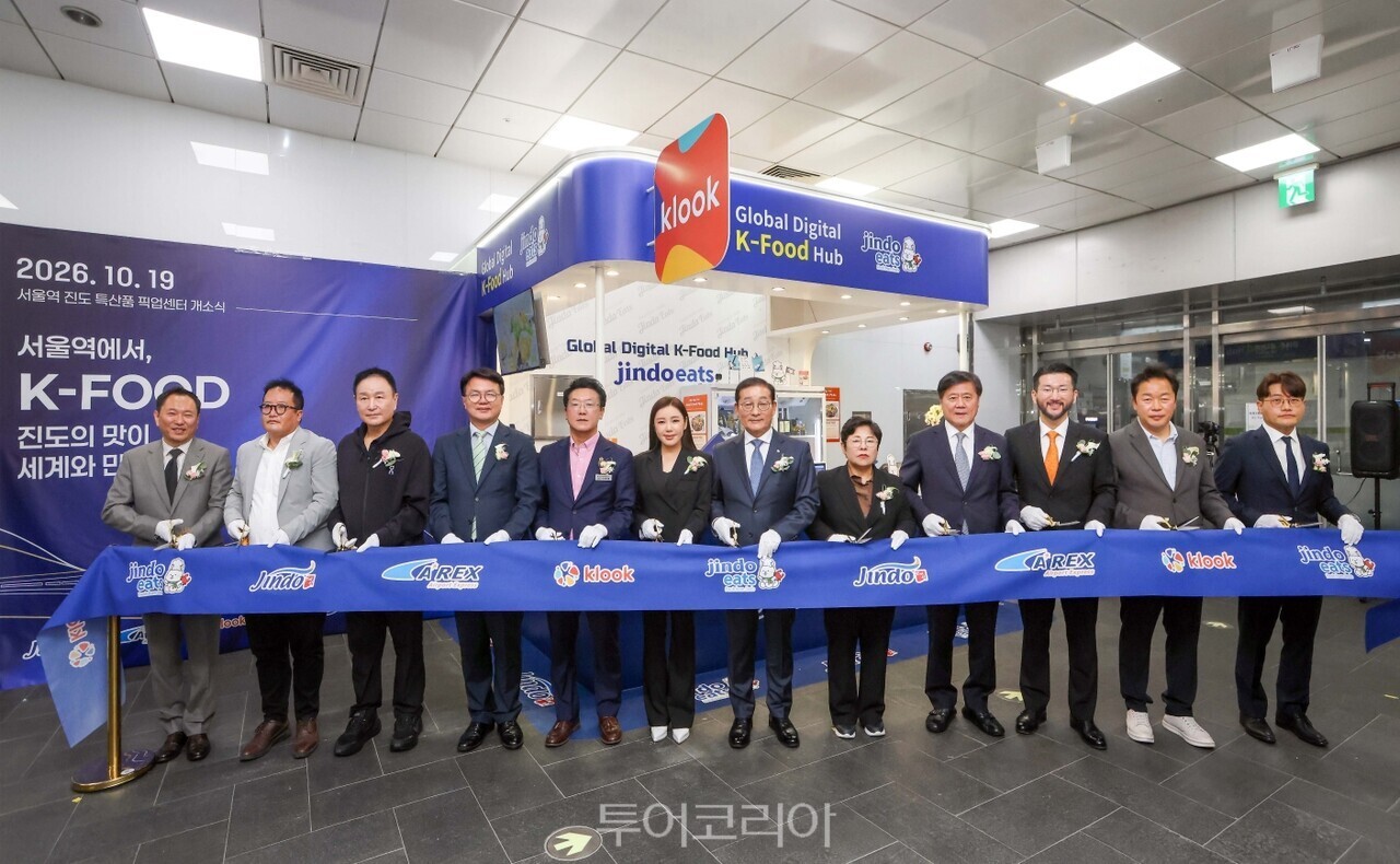 (왼쪽부터) 박정 푸디 대표, 김재명 조선일보 본부장, 허정무 대전하나시티즌 이사장, 조주현 중소기업벤처연구원장, 이현명 전남광주통합특별시의회 의원, 송가인 진도군 홍보대사, 이재각 진도군수, 김춘화 진도군의회 의장, 박대수 공항철도 대표이사, 이준호 클룩 한국 지사장, 설창욱 국토교통부 PM, 민준식 JTBC 본부장이 개관 기념 컷팅식을 진행하고 있다.   서울역 공항철도 지하2층 탑승장 인근 클룩-진도잇츠 픽업센터   진도잇츠 상품/사진-클룩