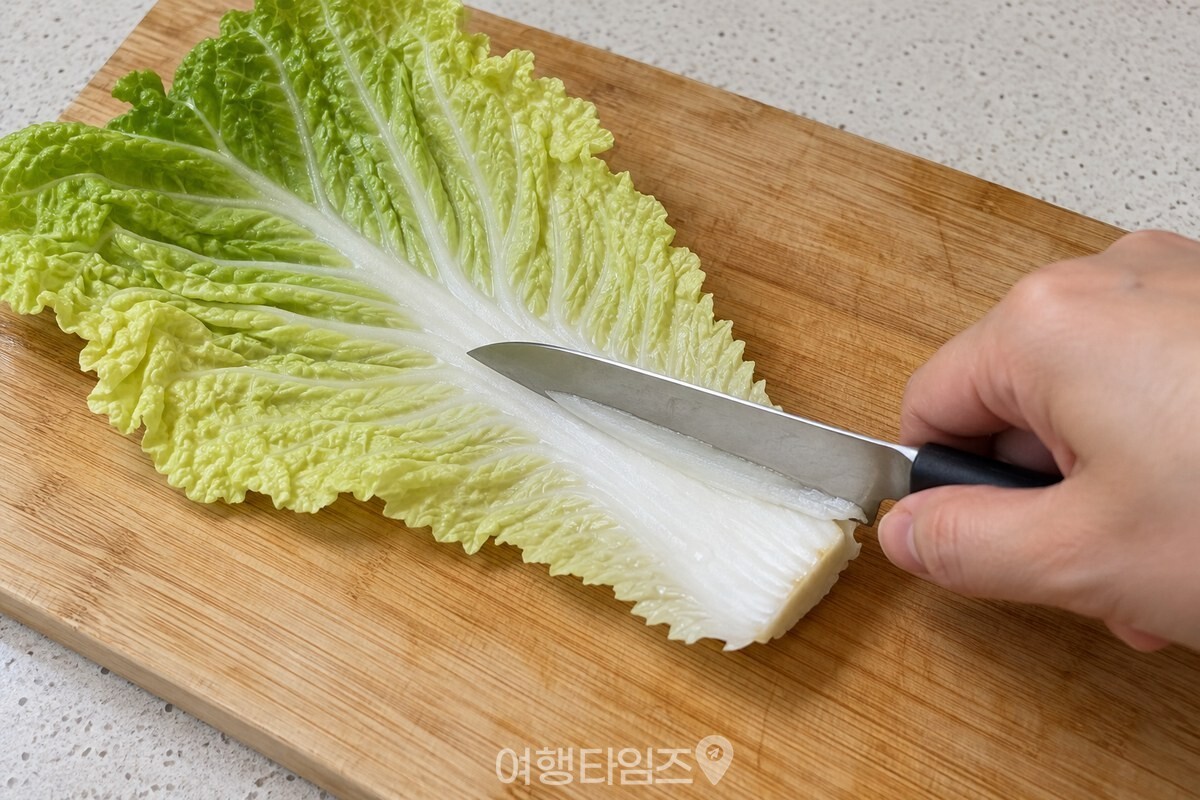 두툼한 배추 줄기 부분을 칼로 얇게 저미는 준비 과정. / 기사 이해를 돕기 위한 생성형 이미지