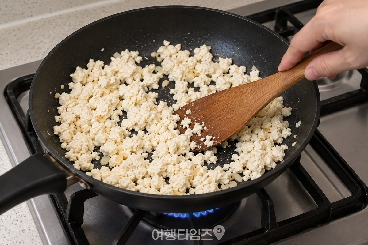 팬에서 으깬 두부를 주걱으로 고르게 볶는 모습. / 기사 이해를 돕기 위한 생성형 이미지