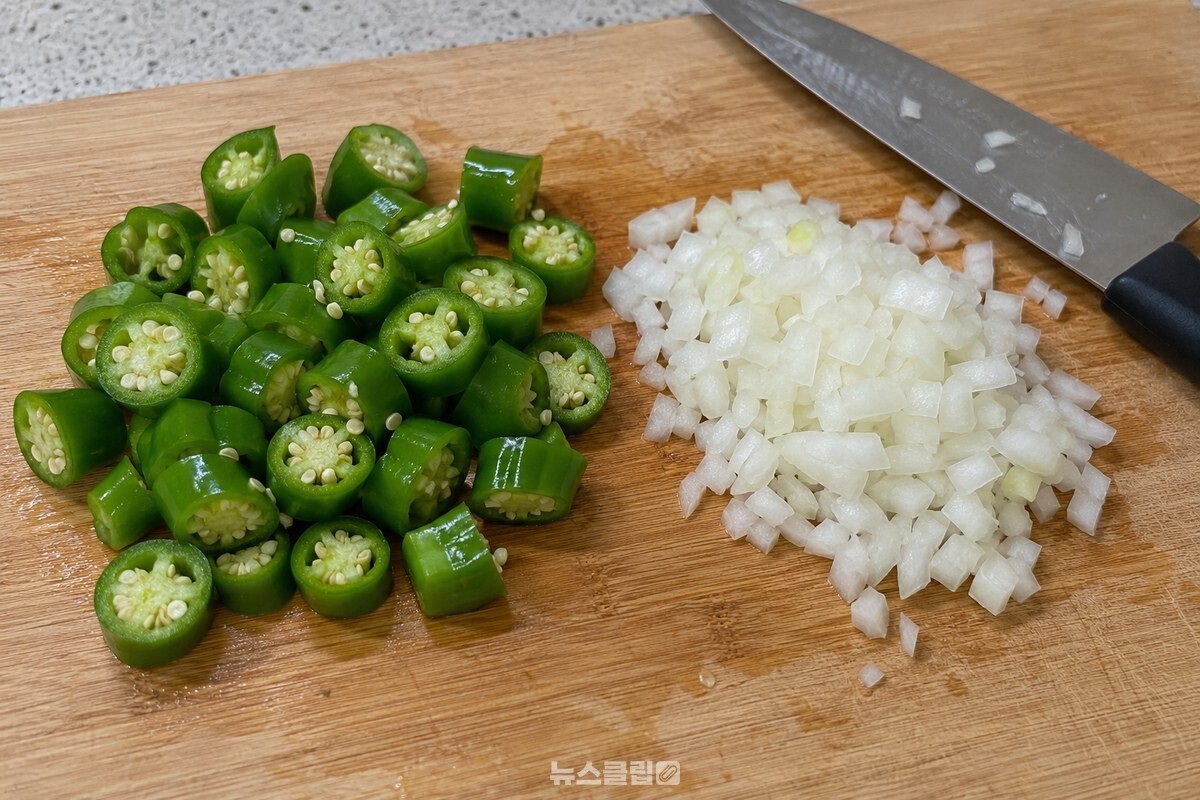 1.5~2cm 두께로 썬 오이고추와 잘게 썬 양파가 도마 위에 놓여 있다. / 기사 이해를 돕기 위한 생성형 이미지