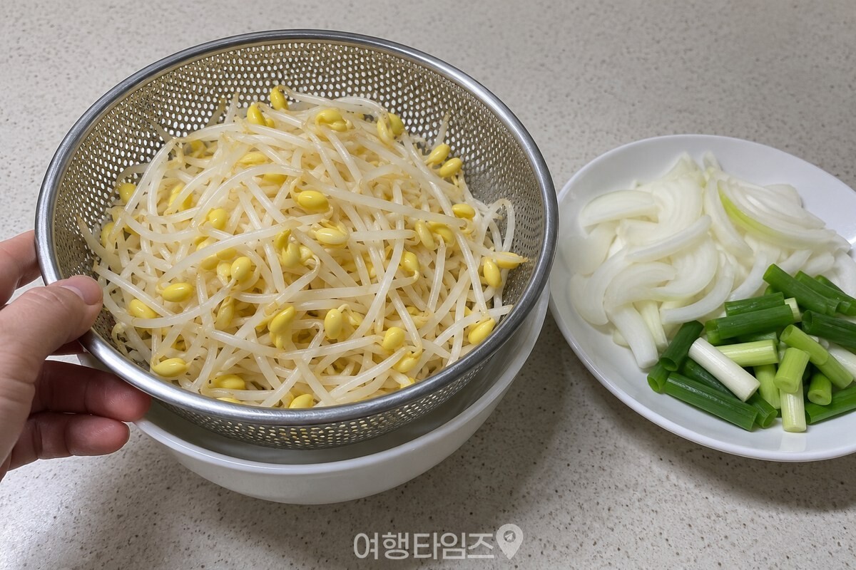 씻어 물기를 뺀 콩나물이 체에 담겨 있고 손질한 양파와 대파가 옆에 놓여 있다. / 기사 이해를 돕기 위한 생성형 이미지