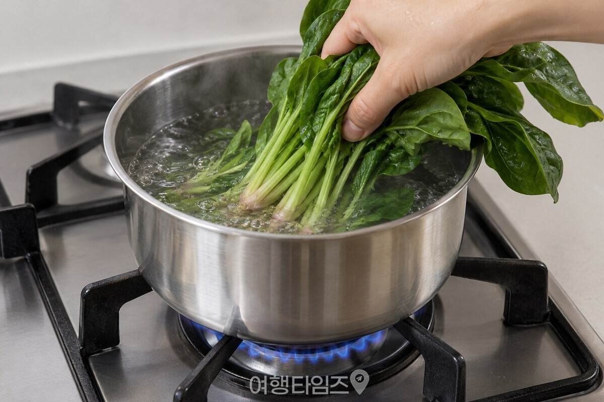 끓는 물에 시금치 뿌리 쪽부터 넣어 짧게 데치는 모습. / 기사 이해를 돕기 위한 생성형 이미지