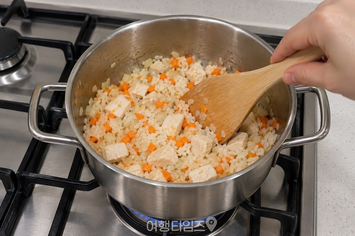 냄비에서 닭가슴살과 채소, 불린 쌀을 주걱으로 볶는 모습. / 기사 이해를 돕기 위한 생성형 이미지
