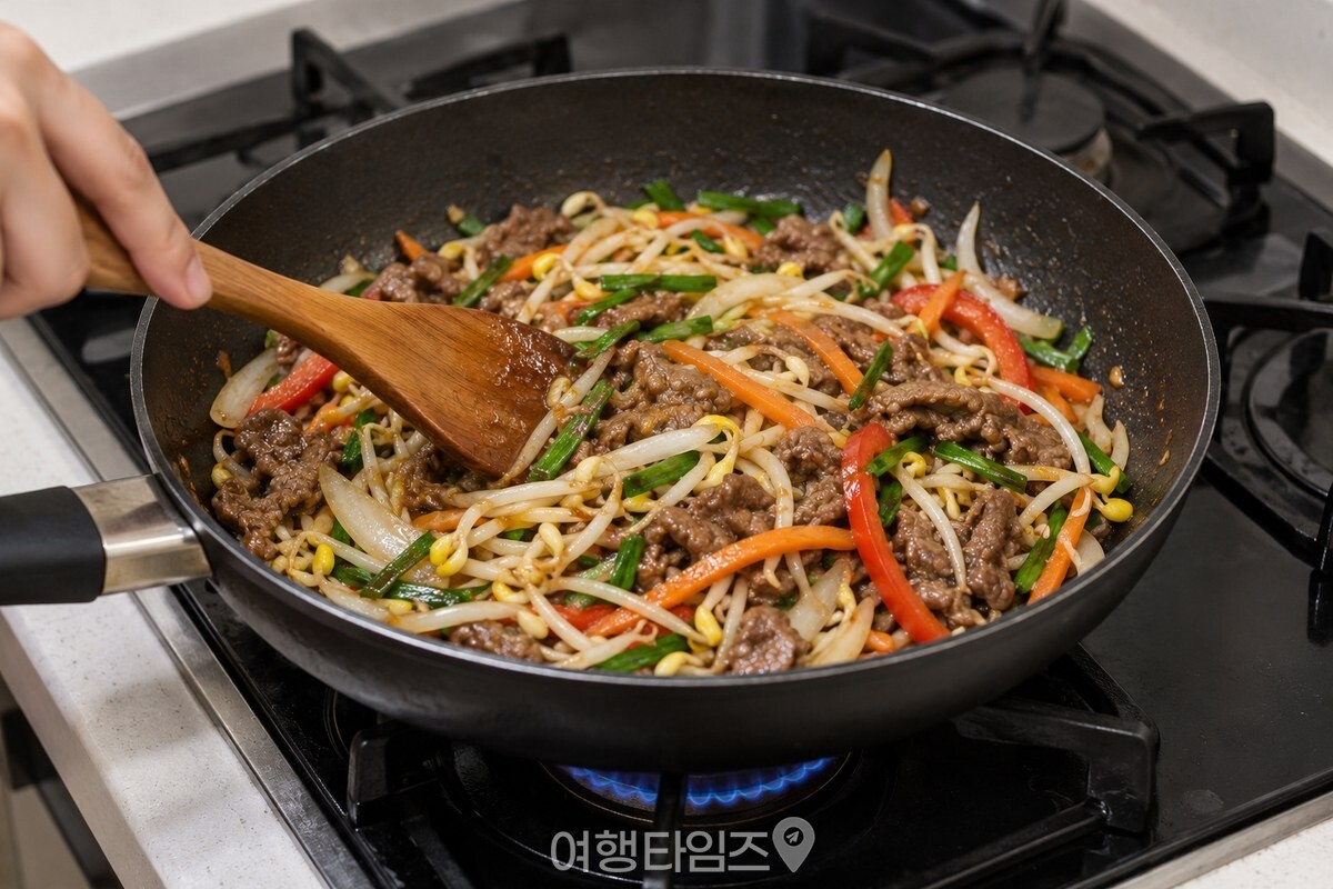 팬에서 소고기와 채소, 콩나물을 센 불에 빠르게 볶는 모습. / 기사 이해를 돕기 위한 생성형 이미지