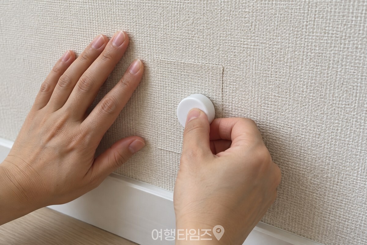 딱풀 뚜껑의 매끈한 윗면으로 붙인 벽지 조각을 가볍게 누르는 모습. / 기사 이해를 돕기 위한 생성형 이미지