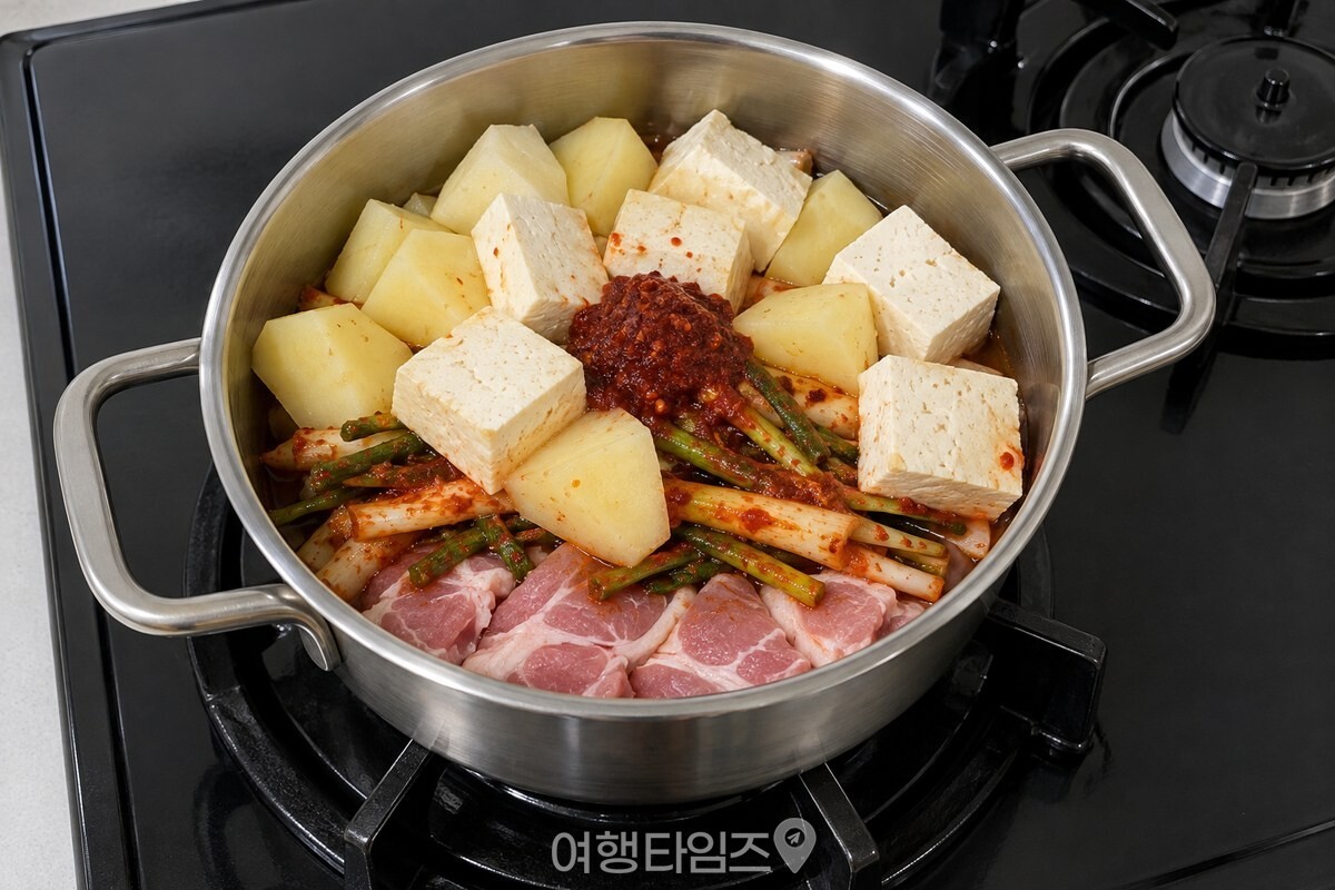 냄비 안에 돼지고기 위로 파김치, 감자, 두부를 층층이 올려 끓이기 전 상태로 준비한 모습 / 기사 이해를 돕기 위한 생성형 이미지