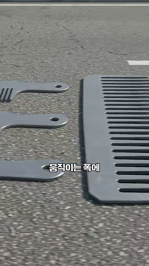 도로 위에 놓인 빗살 모양의 금속판 부품 3개가 나란히 배치되어 있고 그 옆에 더 큰 크기의 빗살판이 놓여 있는 모습.