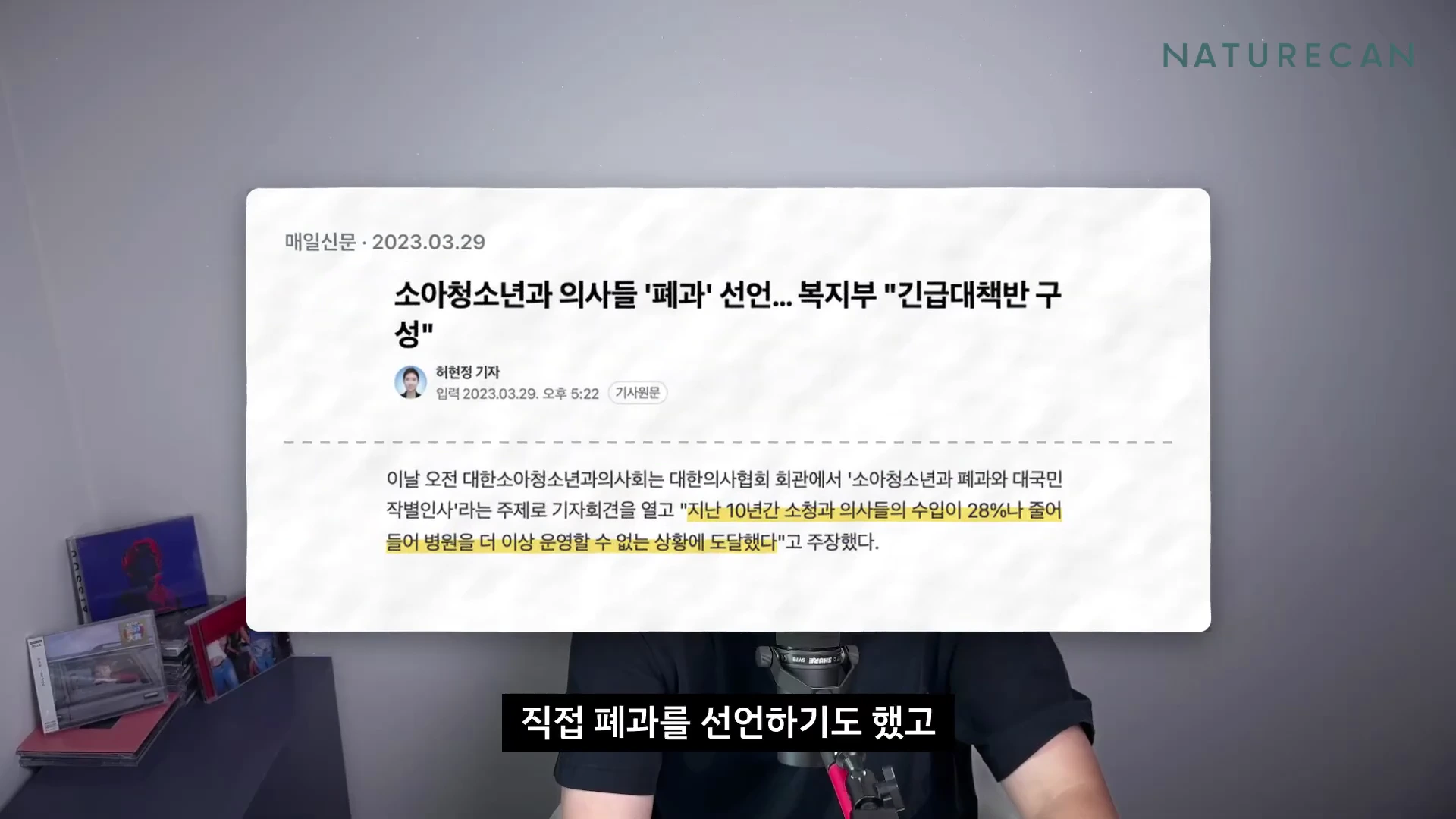 화면 중앙에 '소아청소년과 의사들 폐과 선언'이라는 제목의 뉴스 기사 캡처본이 떠 있고 하단에는 마이크 앞에 앉은 사람의 모습이 일부 보입니다.