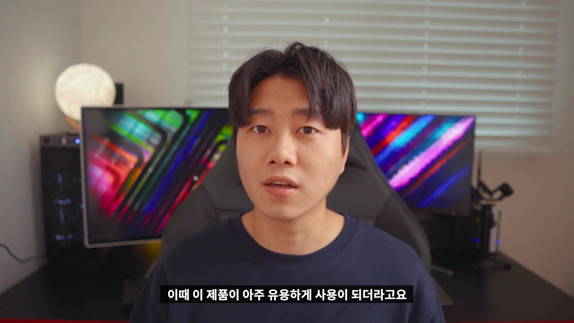 두 개의 모니터가 놓인 책상 앞에 앉아 있는 남성의 상반신 화면.