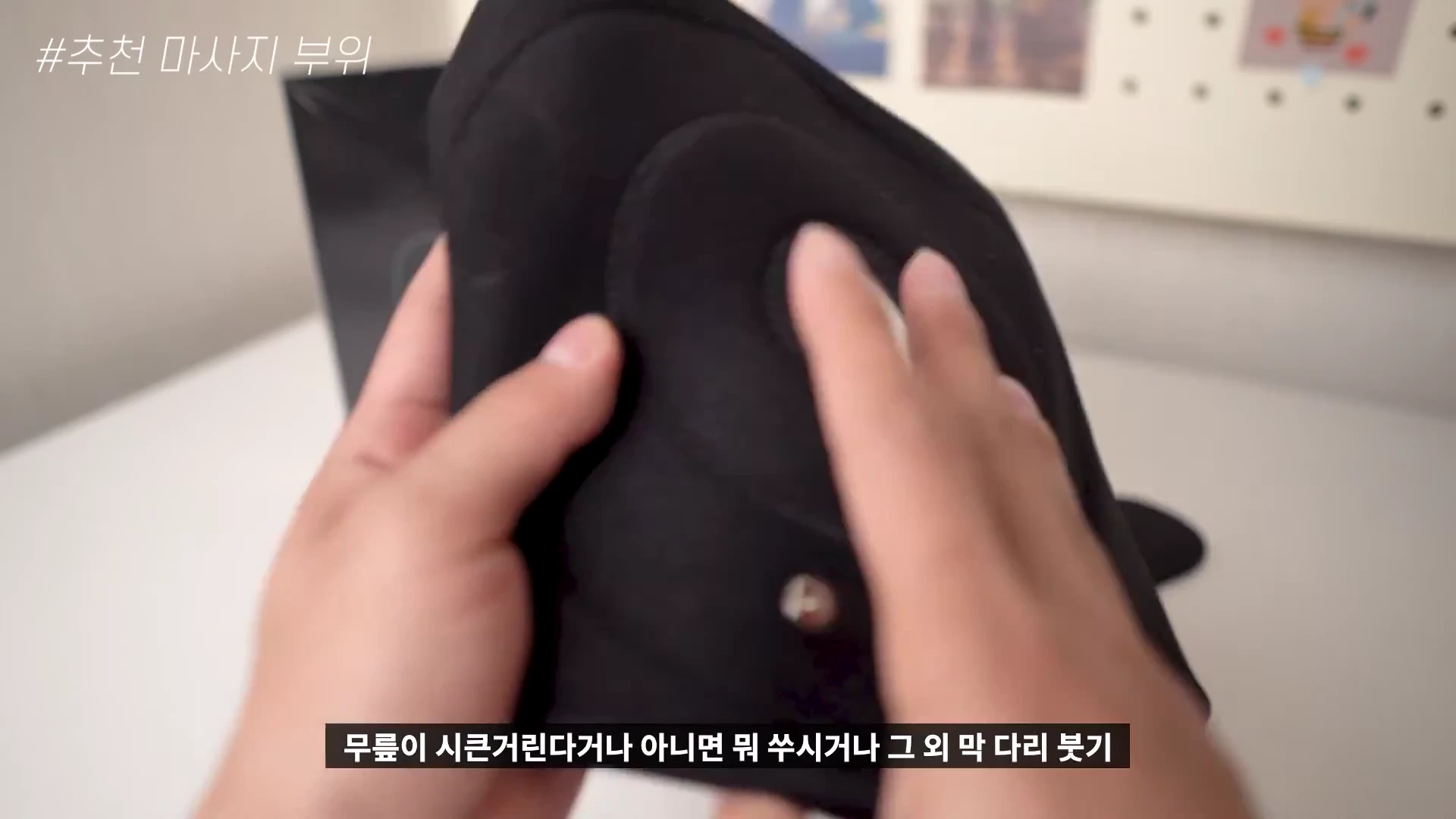 두 손으로 검은색 무릎 밴드를 잡고 보여주는 모습.