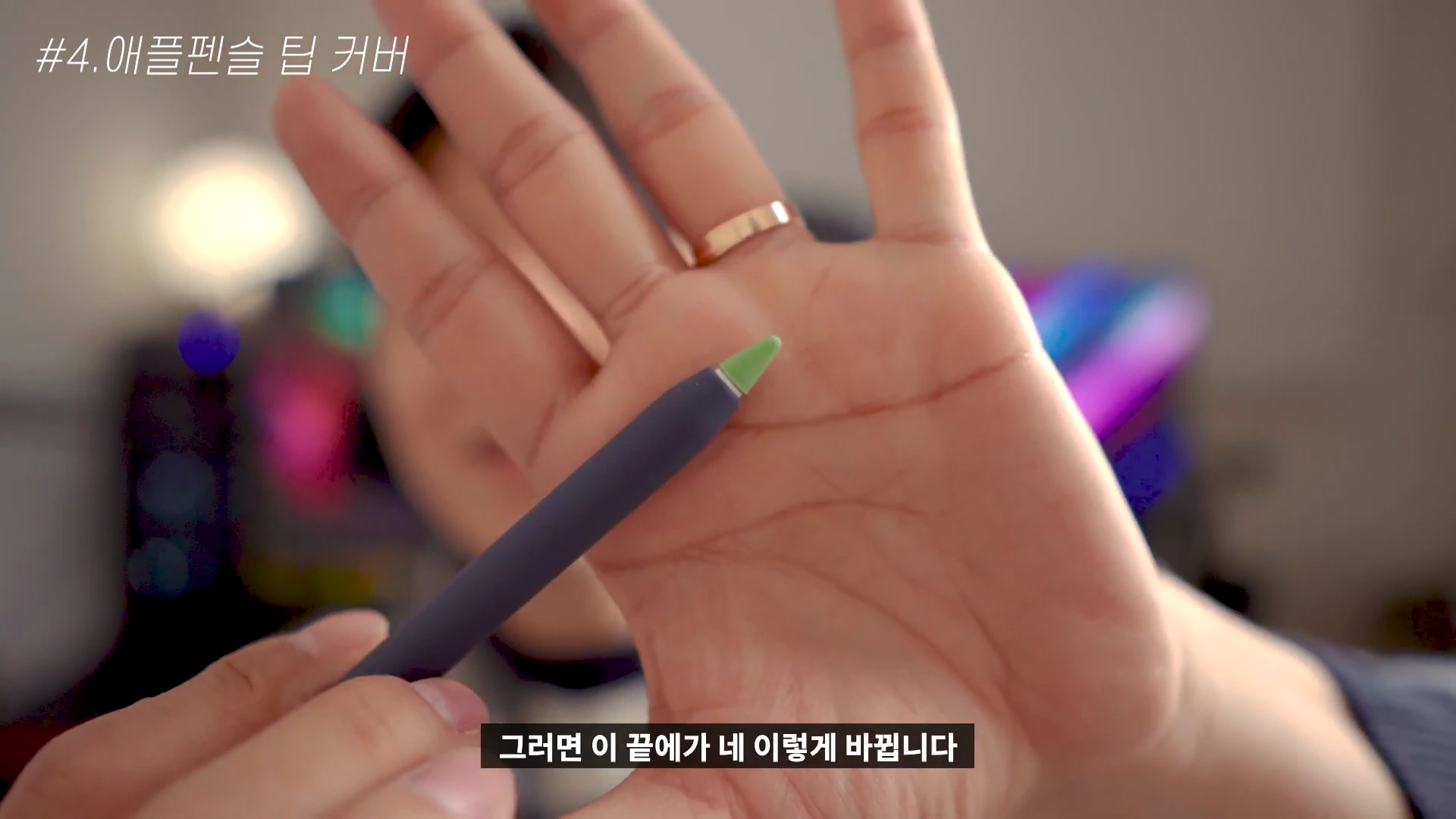 사람 손바닥 위에 연두색 팁 커버를 씌운 애플펜슬이 놓여 있는 모습