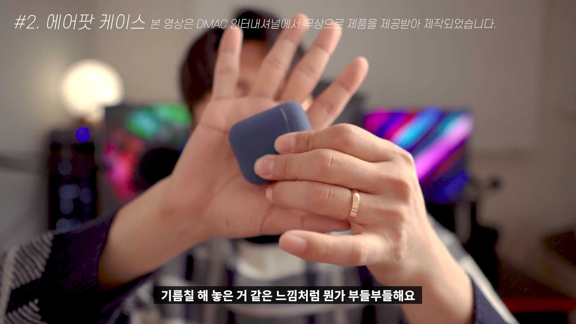 한 남성이 파스텔 톤의 에어팟 케이스를 손바닥 위에 올려놓고 보여주고 있는 모습